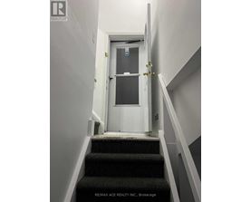 A white door with a glass window is at the end of a staircase.
