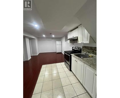 A kitchen with white cabinets and a black stove top oven.