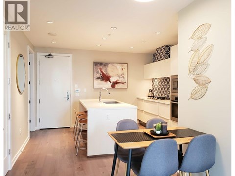 A kitchen with a table and chairs and a painting on the wall.