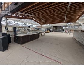 A large, empty warehouse with a high ceiling and wooden beams.