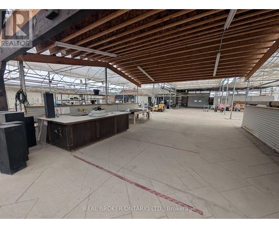 A large, empty warehouse with a high ceiling and wooden beams.