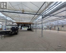 A large, empty warehouse with a white ceiling and a truck parked inside.