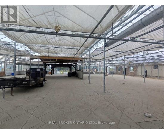A large, empty warehouse with a white ceiling and a truck parked inside.