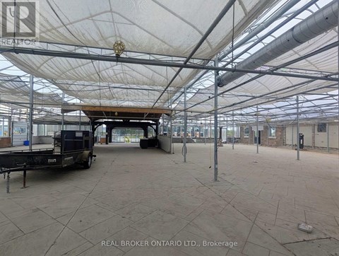 A large, empty warehouse with a white ceiling and a truck parked inside.