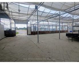 A large, empty warehouse with a tiled floor and a glass roof.