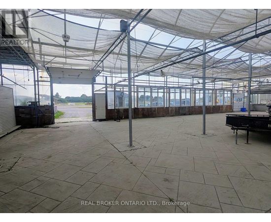 A large, empty warehouse with a tiled floor and a glass roof.