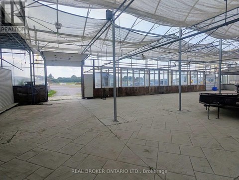 A large, empty warehouse with a tiled floor and a glass roof.