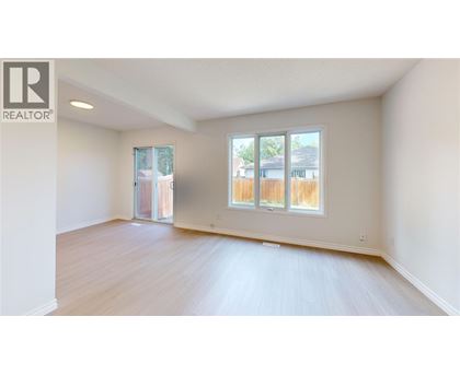 A spacious room with a sliding glass door leading to a backyard.
