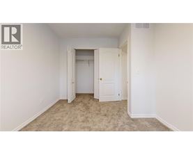 A bedroom with a carpeted floor and two doors.