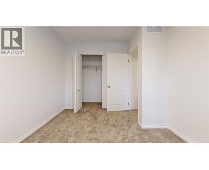 A bedroom with a carpeted floor and two doors.