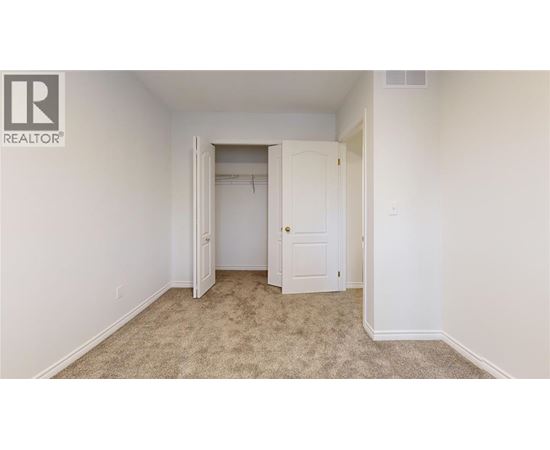 A bedroom with a carpeted floor and two doors.