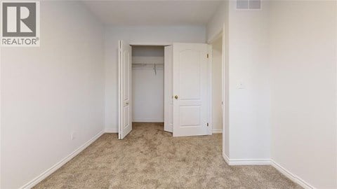 A bedroom with a carpeted floor and two doors.
