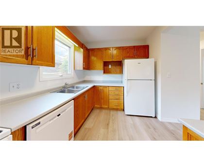 A kitchen with wooden cabinets and white appliances.