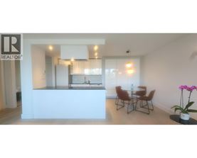 A realtor logo is on the wall of a modern kitchen and dining area.