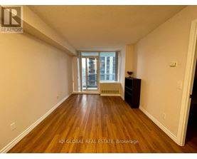 A room with wooden floors and a window with a view of a building outside.