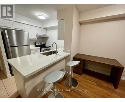 A kitchen with white cabinets and a stainless steel refrigerator.