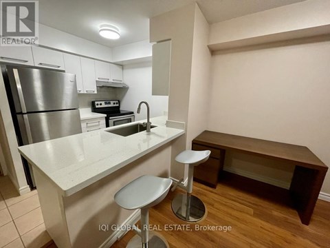 A kitchen with white cabinets and a stainless steel refrigerator.