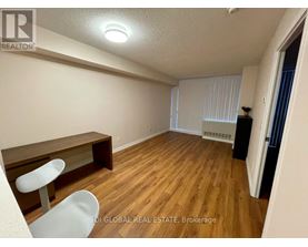 A room with wooden flooring and a white chair.