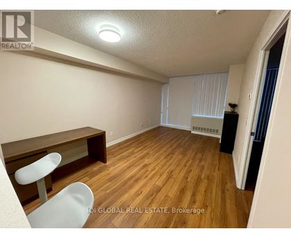 A room with wooden flooring and a white chair.