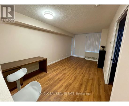 A room with wooden flooring and a white chair.