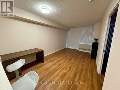A room with wooden flooring and a white chair.