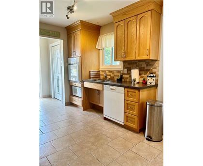 A kitchen with wooden cabinets and a white dishwasher.