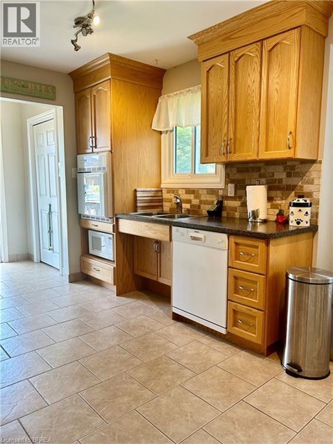 A kitchen with wooden cabinets and a white dishwasher.