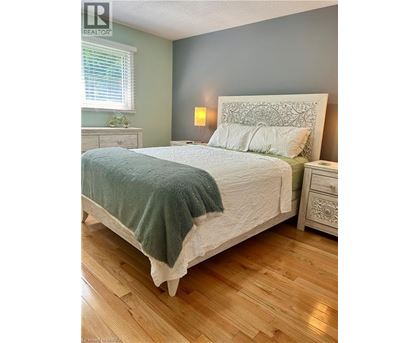A bedroom with a large bed and wooden floors.