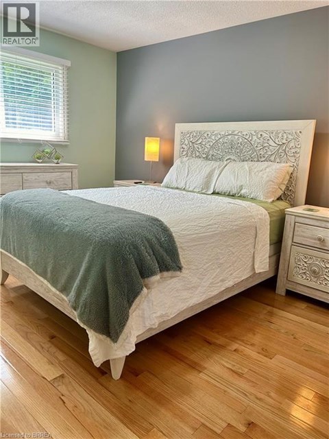 A bedroom with a large bed and wooden floors.