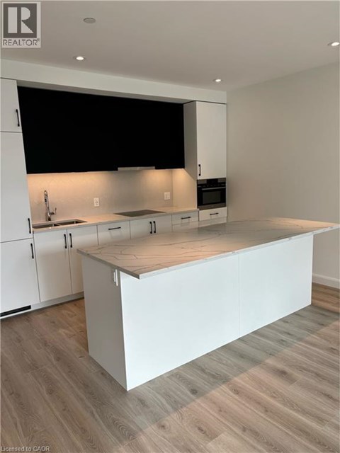 A modern kitchen with white cabinets and a wooden island.