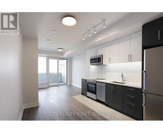 A modern kitchen with black cabinets and stainless steel appliances.