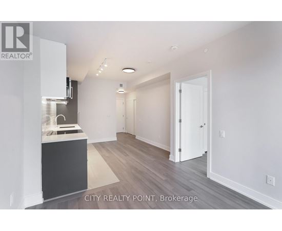 A modern kitchen with white cabinets and a black island.