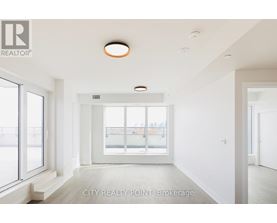 A spacious room with a large window and a view of a balcony.