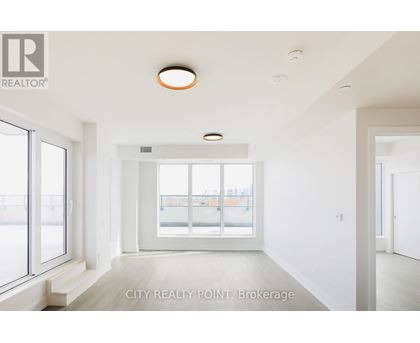 A spacious room with a large window and a view of a balcony.