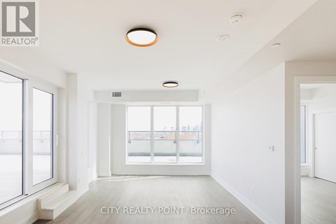 A spacious room with a large window and a view of a balcony.