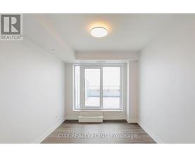 A white room with a window and a light on the ceiling.