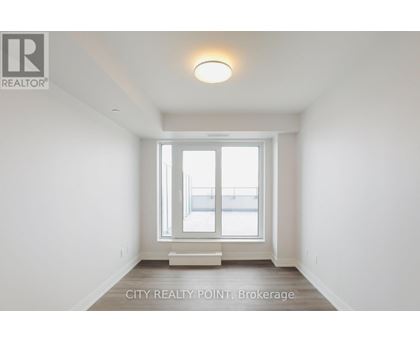 A white room with a window and a light on the ceiling.
