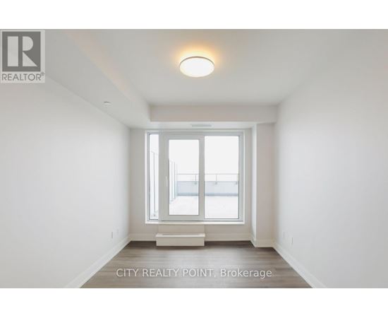 A white room with a window and a light on the ceiling.