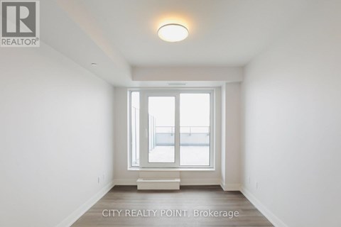 A white room with a window and a light on the ceiling.