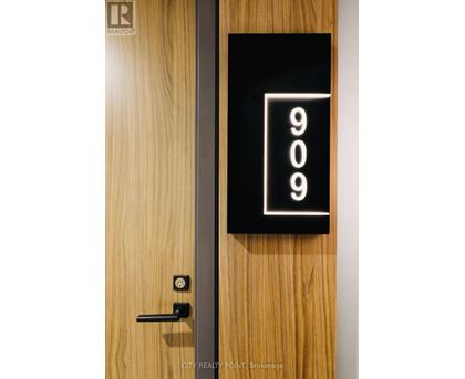A door with a black sign that says 909 on it.