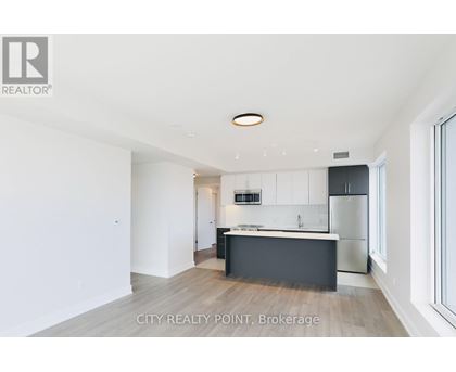 A modern kitchen with white cabinets and a black island.