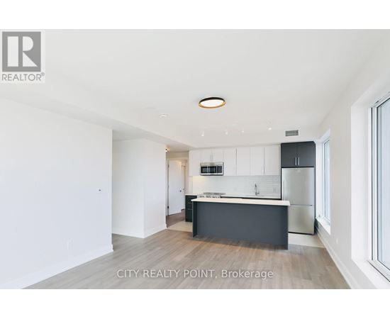 A modern kitchen with white cabinets and a black island.