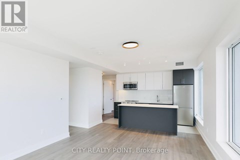 A modern kitchen with white cabinets and a black island.