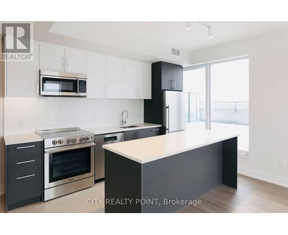 A modern kitchen with a stove top oven, microwave, and a counter top.