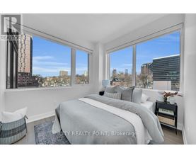 A bedroom with a large bed and a view of the city.