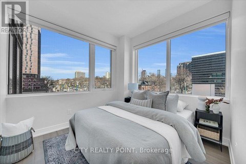 A bedroom with a large bed and a view of the city.