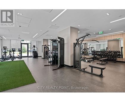 A gym with a variety of equipment including treadmills, weights, and exercise machines.