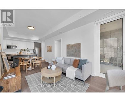 A well-lit living room with a grey sofa and wooden furniture.
