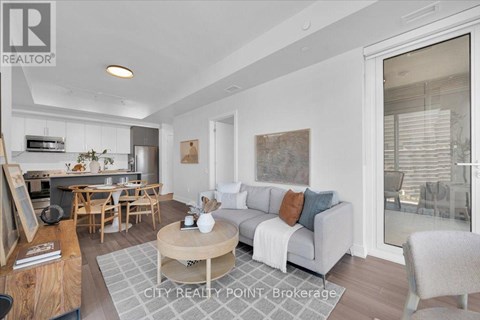 A well-lit living room with a grey sofa and wooden furniture.