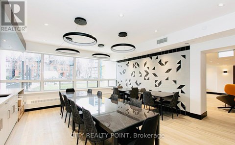 A modern dining room with a large table and chairs.